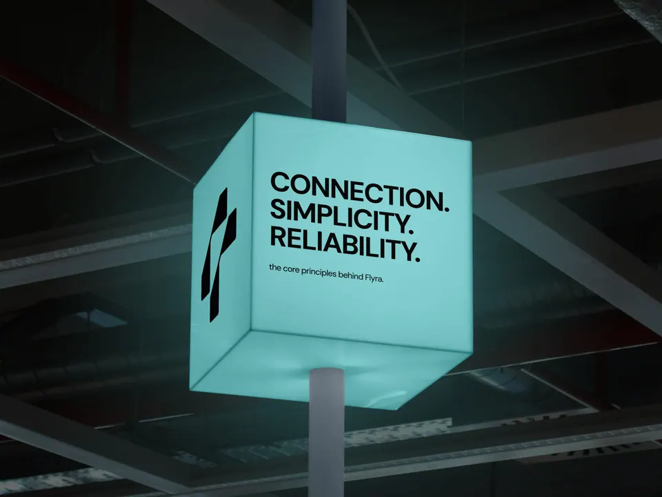 Flyra brand signage — 'Connection. Simplicity. Reliability.' 3D cube